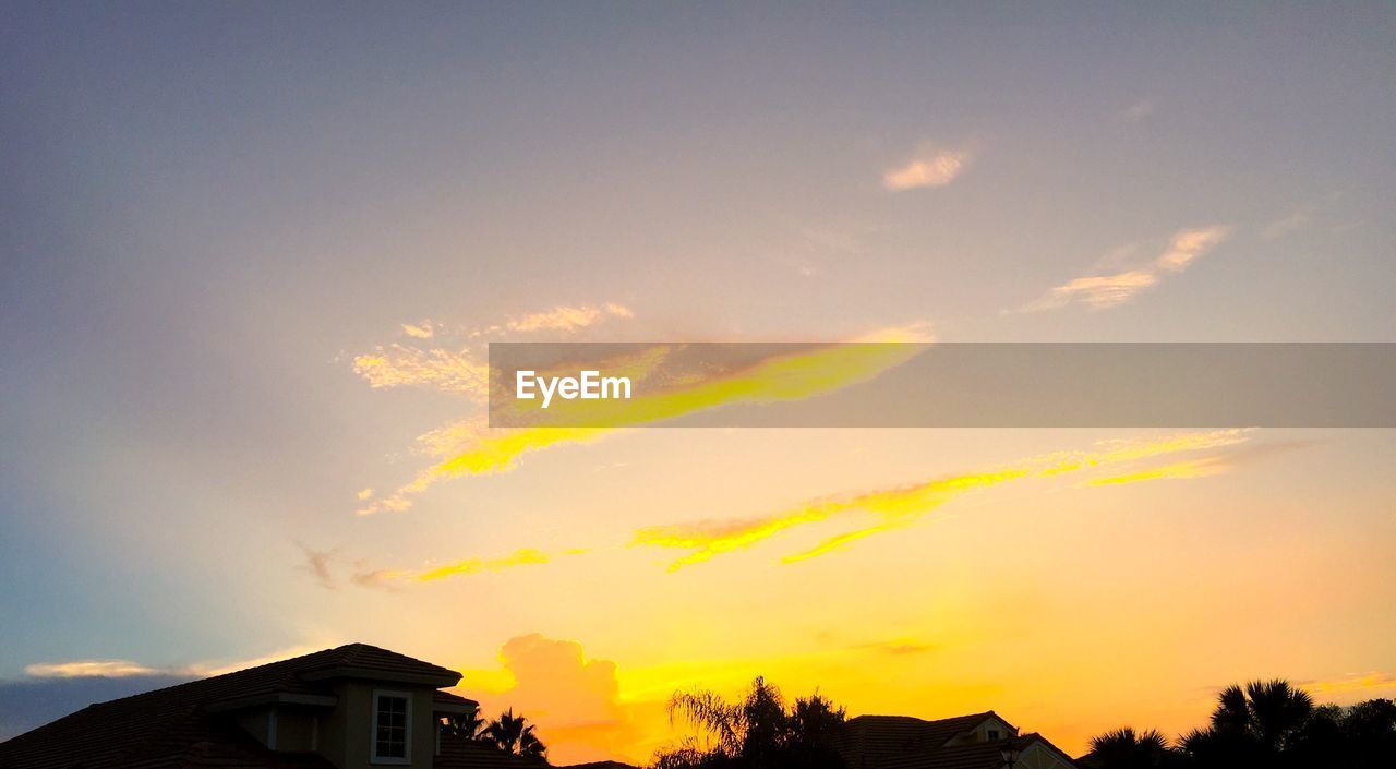 Low angle view of house against sunset sky