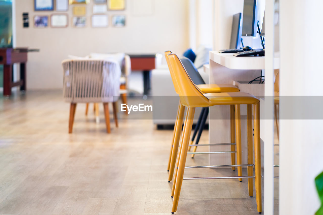 indoors, table, chair, seat, room, furniture, floor, business, home interior, flooring, no people, desk, office, hardwood floor, wood, domestic room, focus on foreground, absence, place of work, technology, day, architecture, education