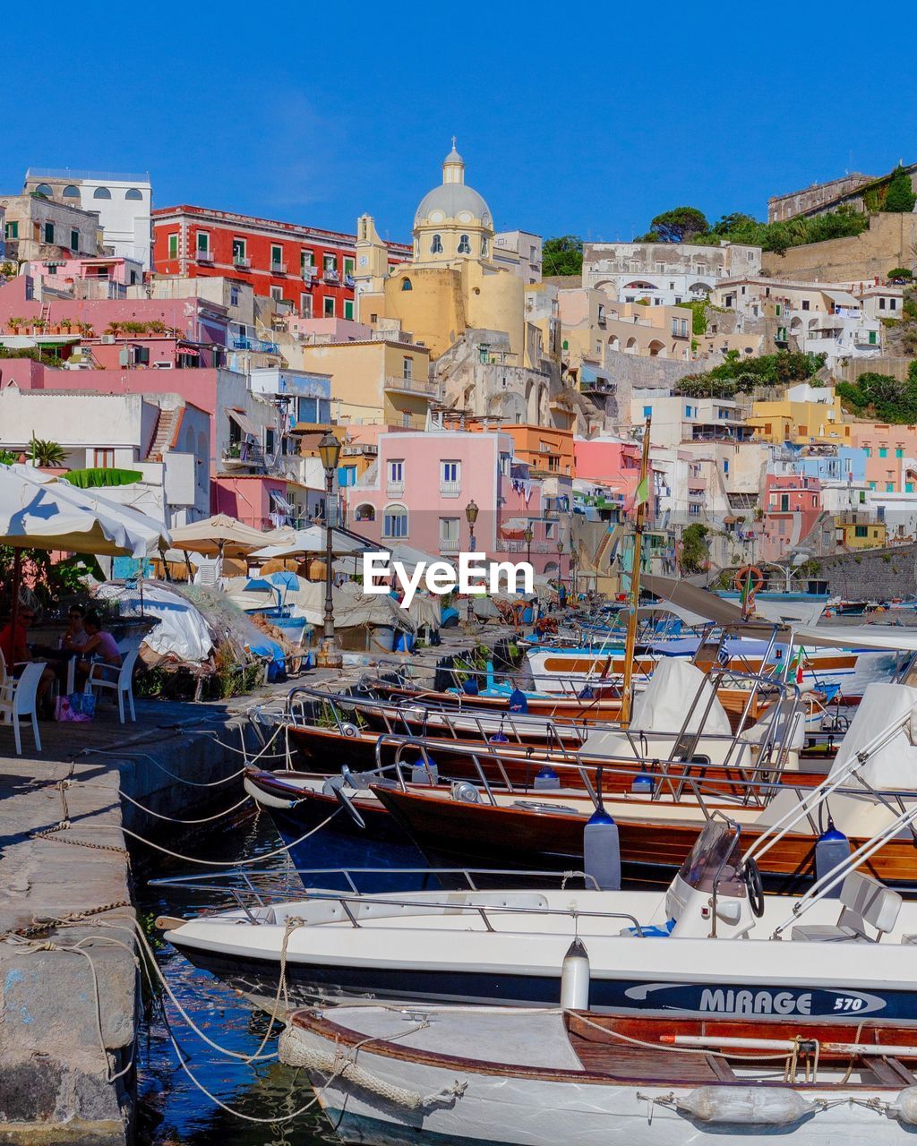 BOATS MOORED AT HARBOR AGAINST BUILDINGS