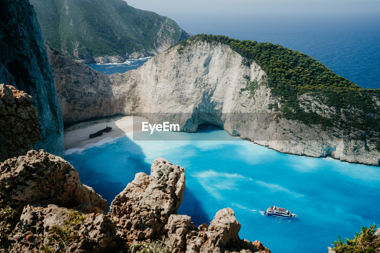 Aerial view of rocks by sea against sky