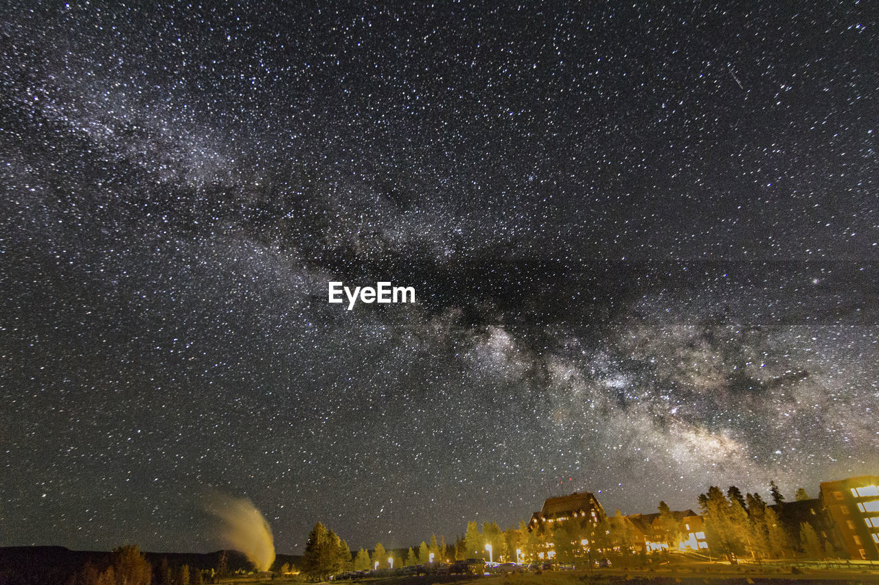 Scenic view of star field over illuminated yellowstone national park at night