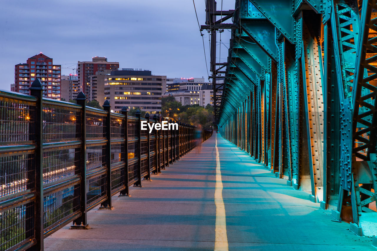 Blurred motion of person walking on bridge during sunset