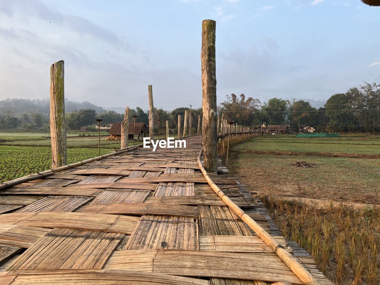 sky, landscape, wood, track, nature, environment, cloud, plant, rural scene, architecture, land, tree, no people, scenics - nature, rural area, transport, field, outdoors, agriculture, travel, grass, travel destinations, built structure, walkway, business finance and industry, day, tranquility, beauty in nature, non-urban scene, outdoor structure