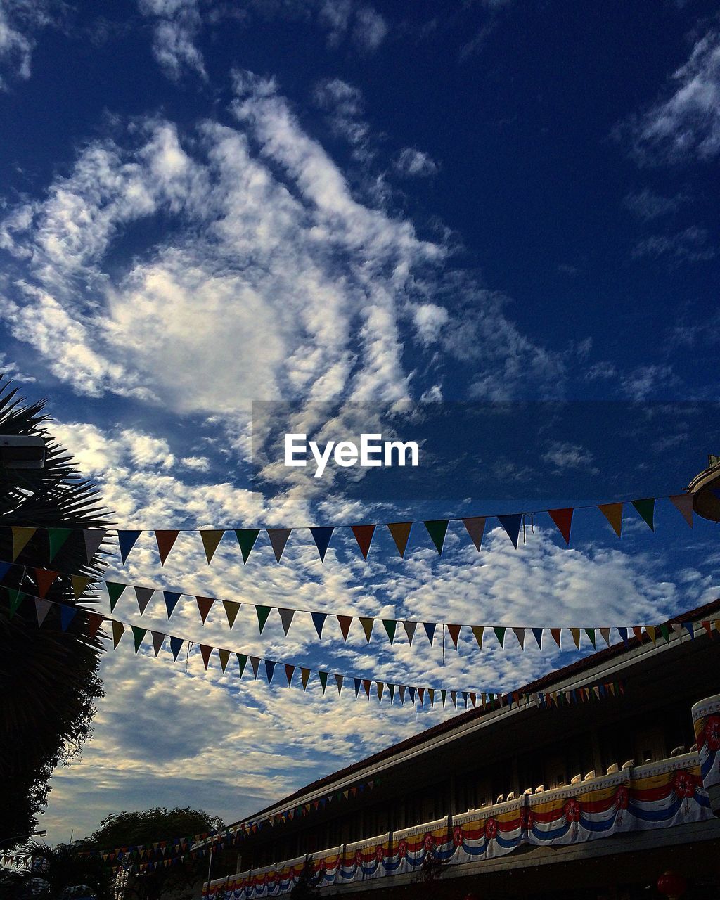 Low angle view of bunting flags hanging from temple against sky