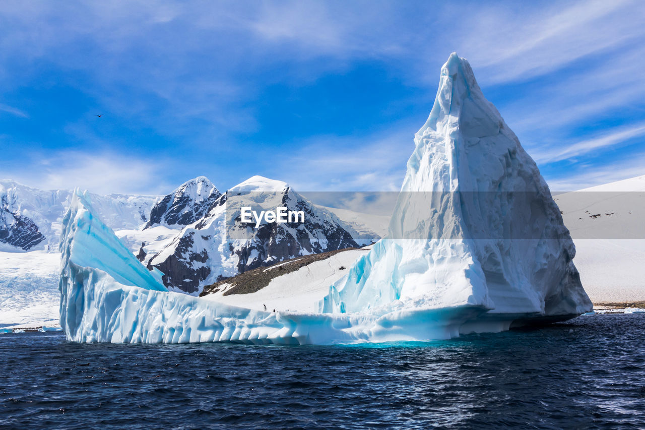 SCENIC VIEW OF SNOWCAPPED MOUNTAIN AGAINST SEA