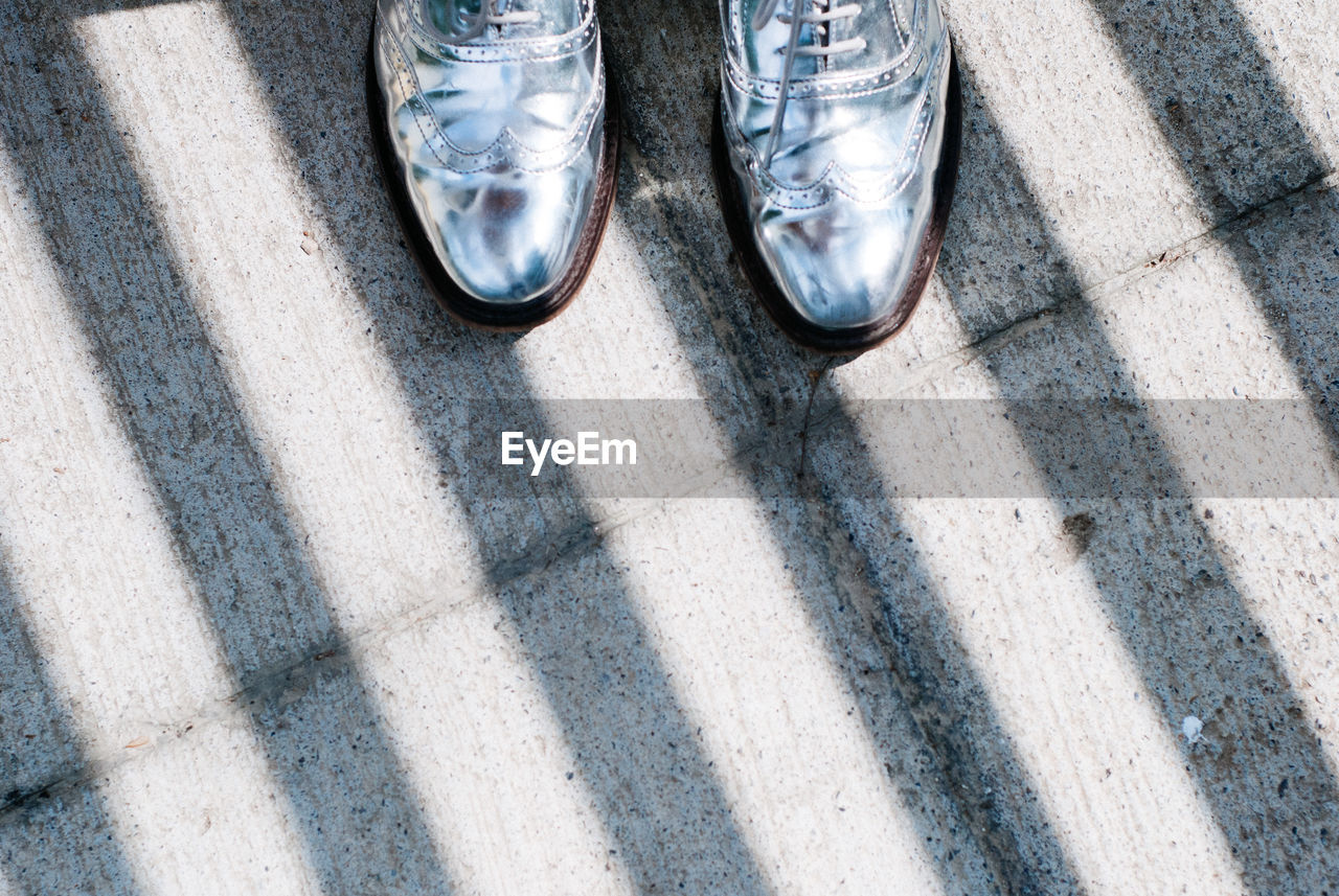 Low section of person standing on road