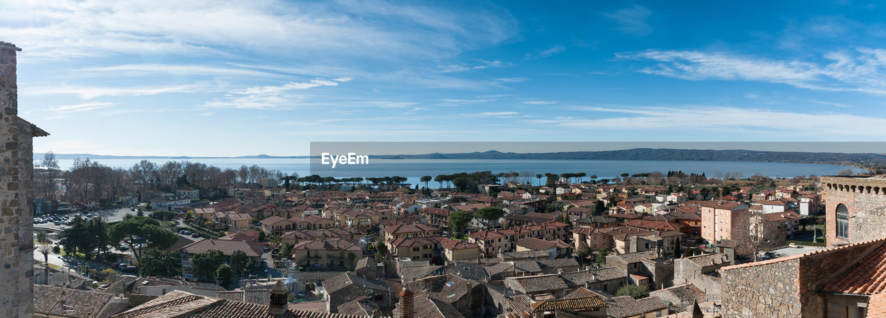 Panoramic view of cityscape by sea against sky