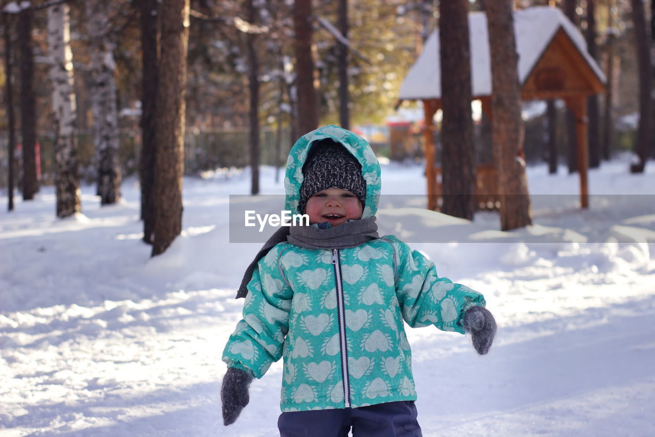 Girl in warm cloth standing on snow covered landscape