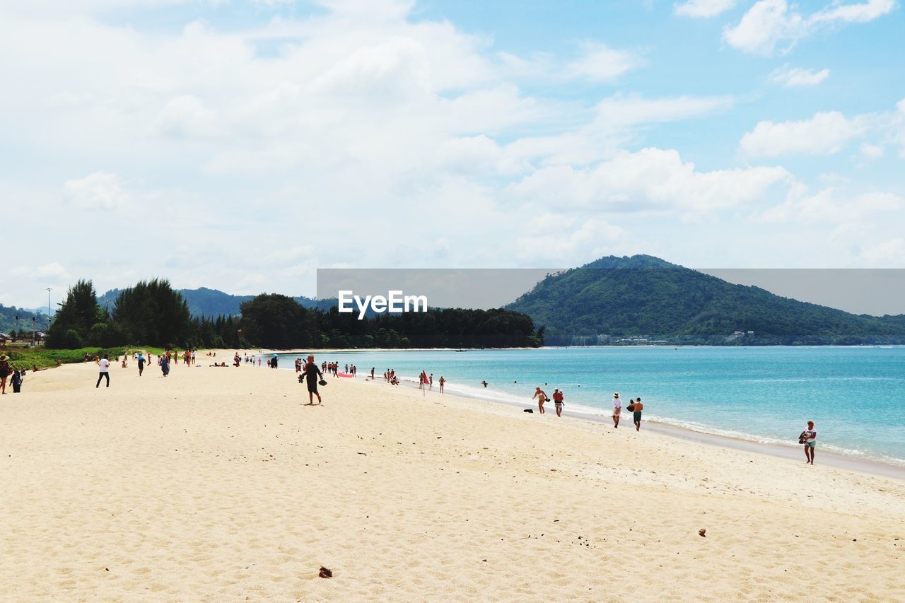 People on beach against sky