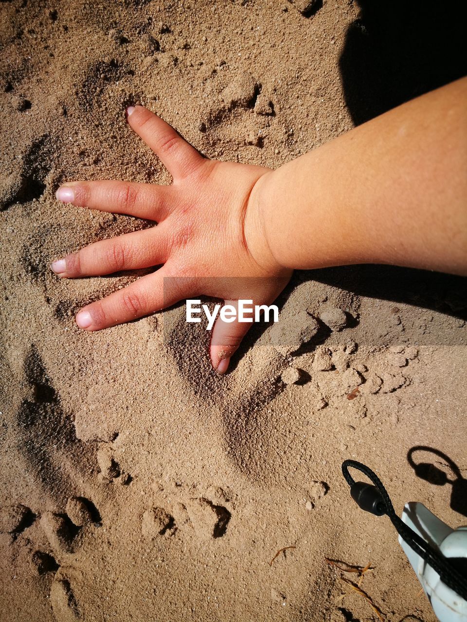 Close-up of baby hand on sand