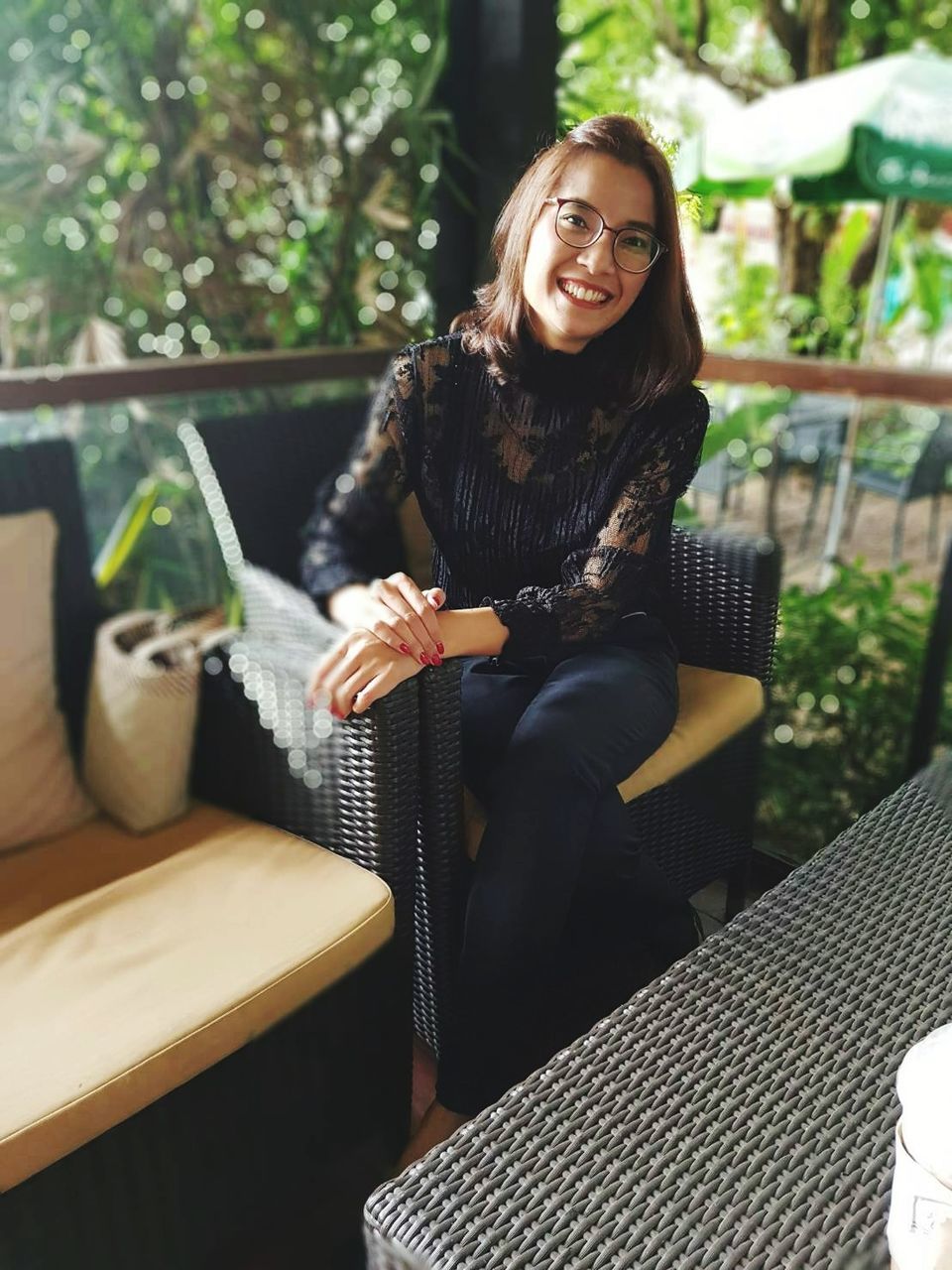 Portrait of smiling woman sitting on chair at cafe