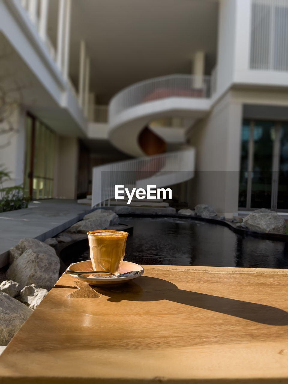 COFFEE CUP ON TABLE AGAINST GLASS