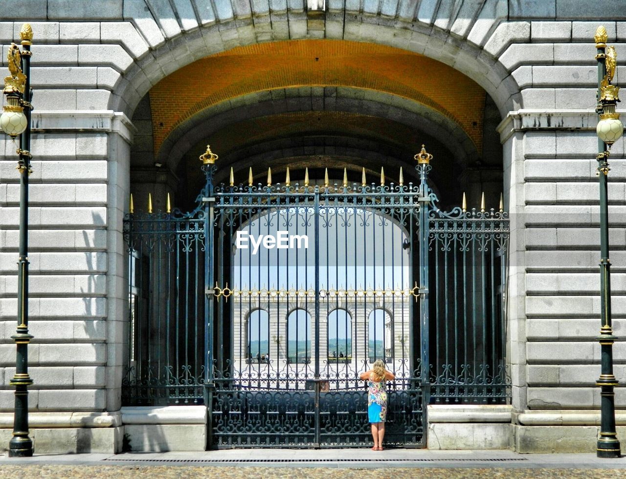 Rear view of woman standing in front of closed gate