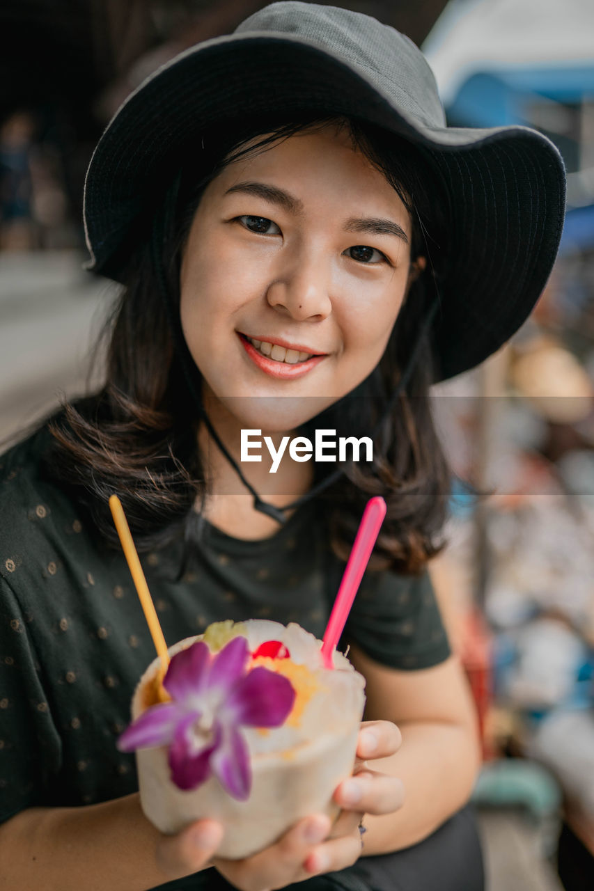 Portrait of smiling young woman holding food in bowl