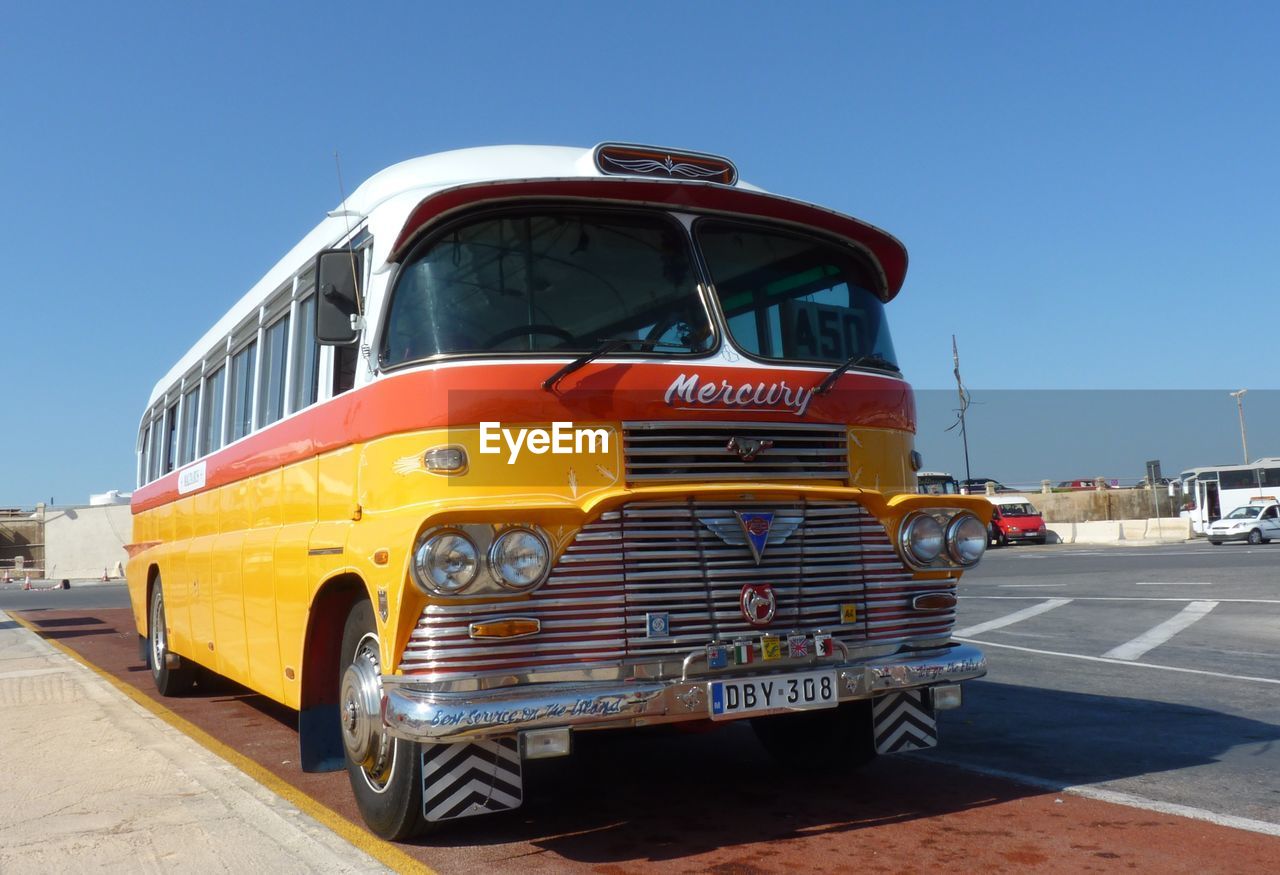 VINTAGE CAR ON ROAD AGAINST CLEAR SKY