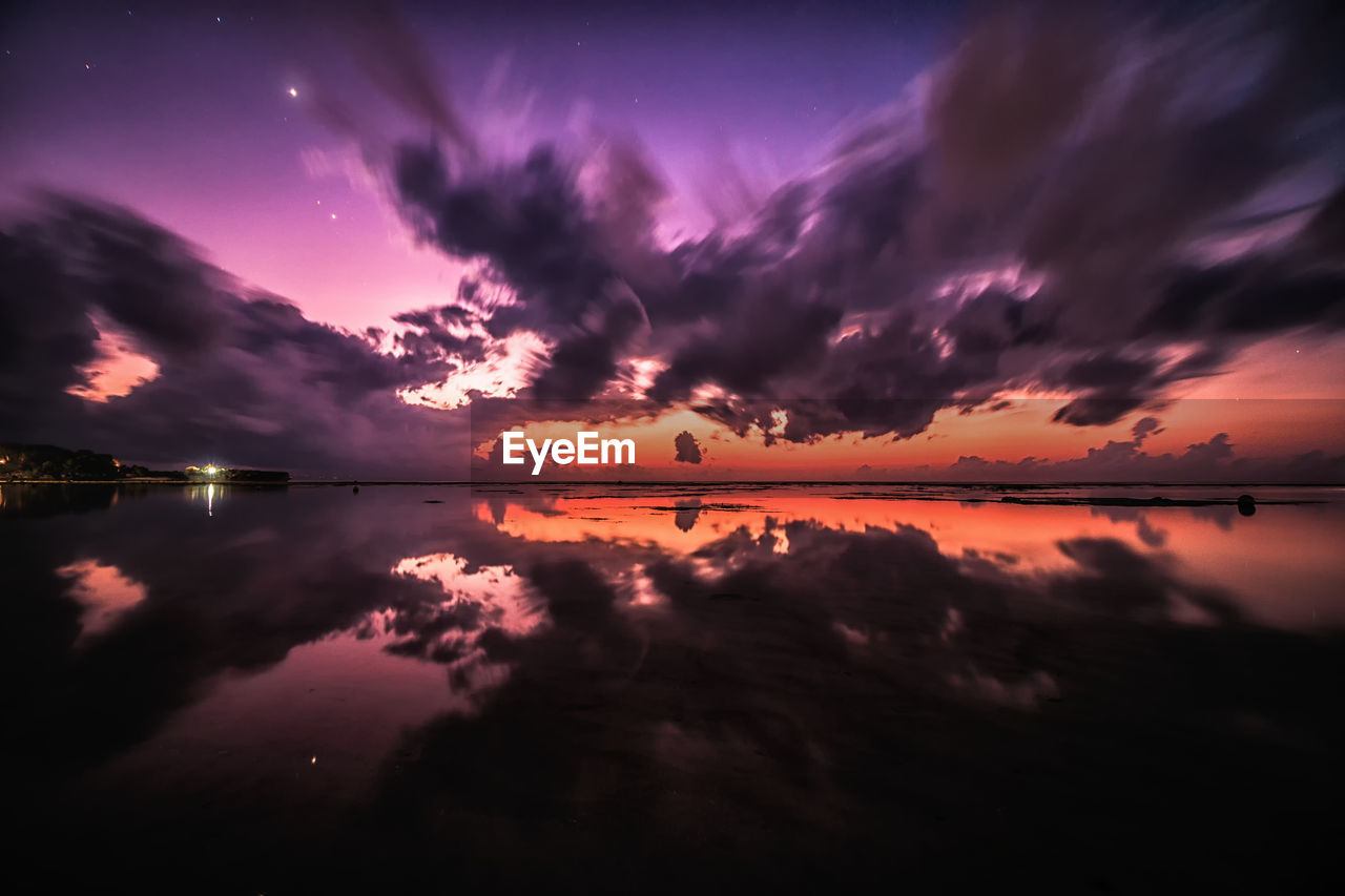 Scenic view of dramatic sky over lake during sunset