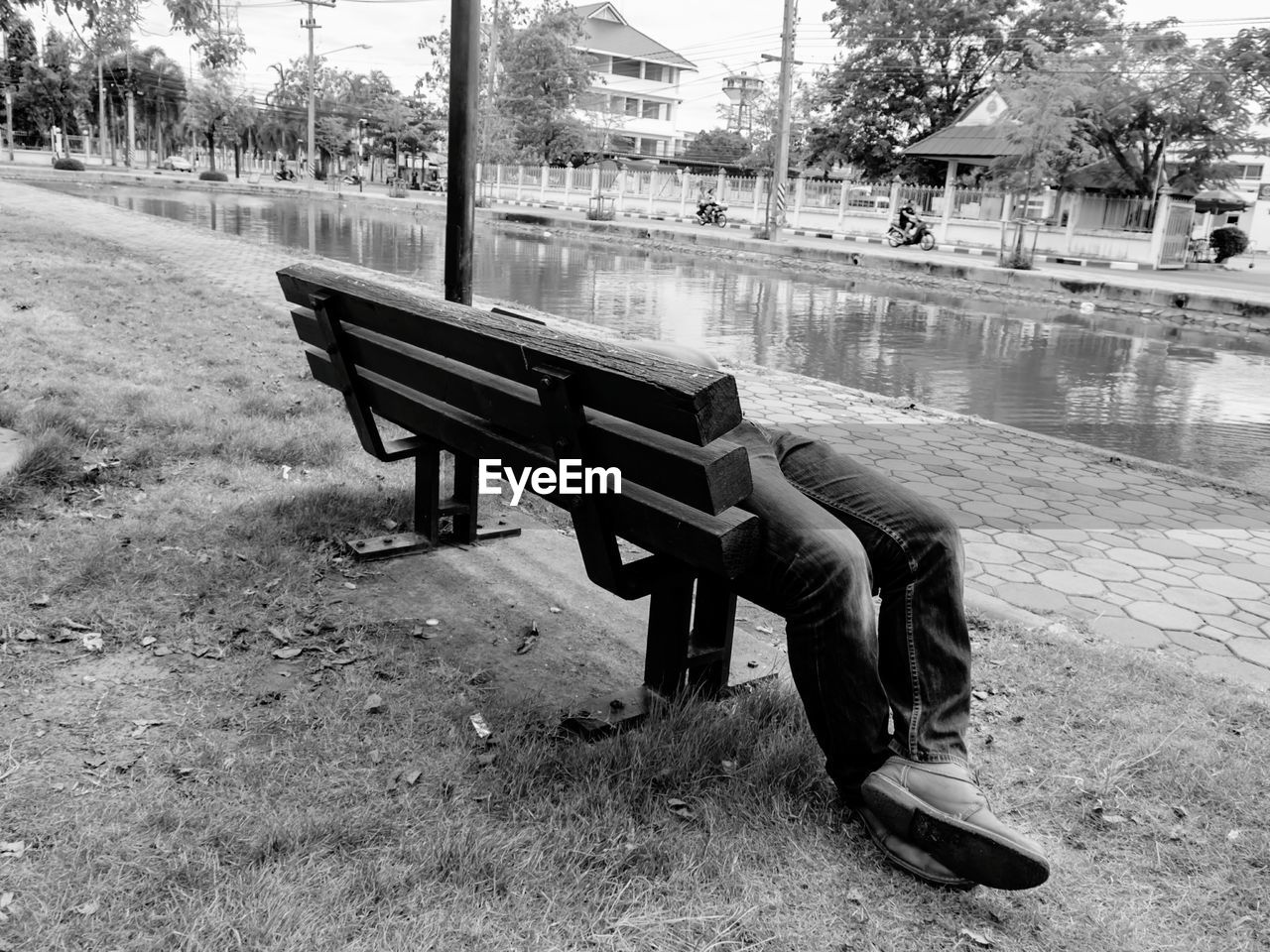 WOMAN SITTING ON SEAT IN PARK