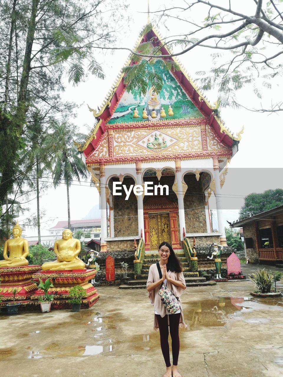 WOMAN STANDING AGAINST TEMPLE