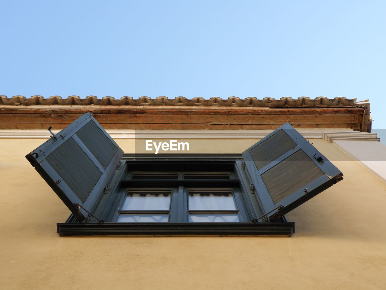 Directly below shot of window of building against clear sky