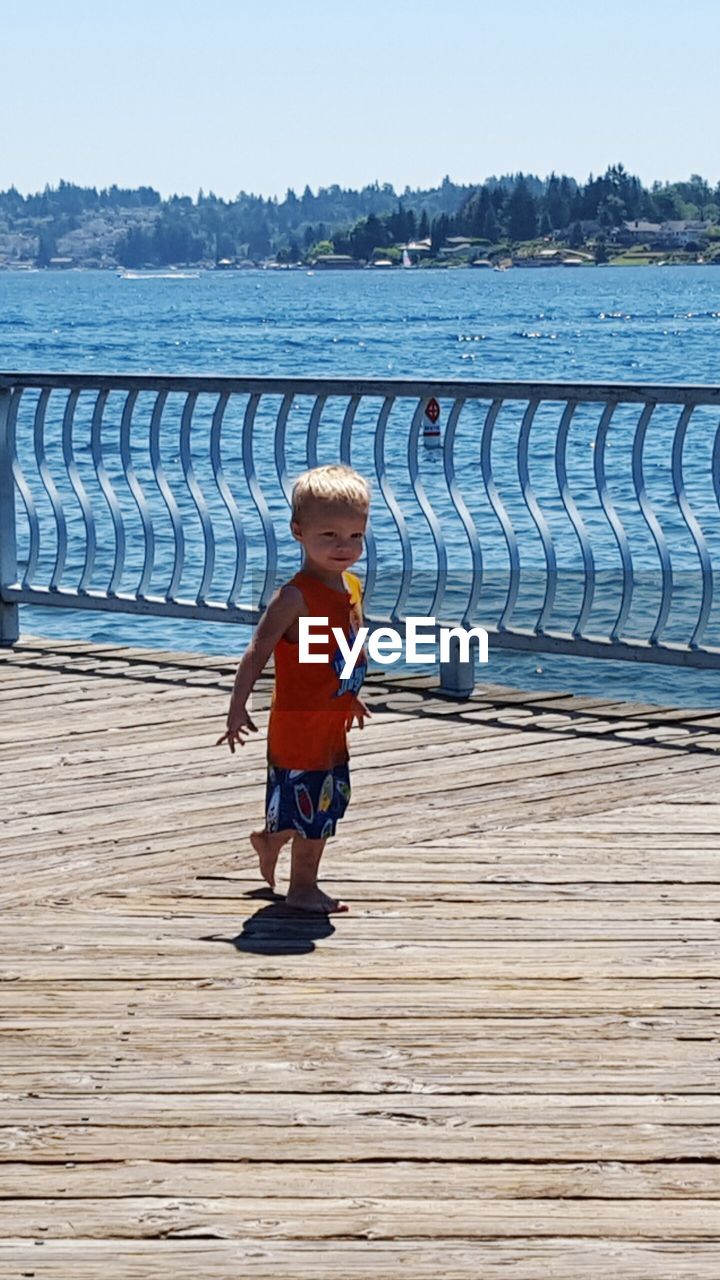 WOMAN WALKING ON PIER