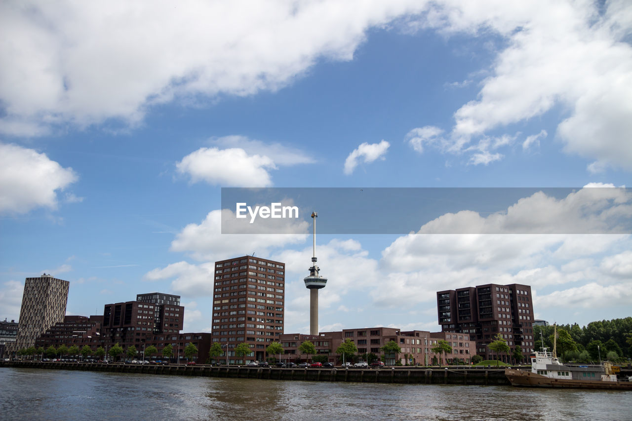 River in city against cloudy sky