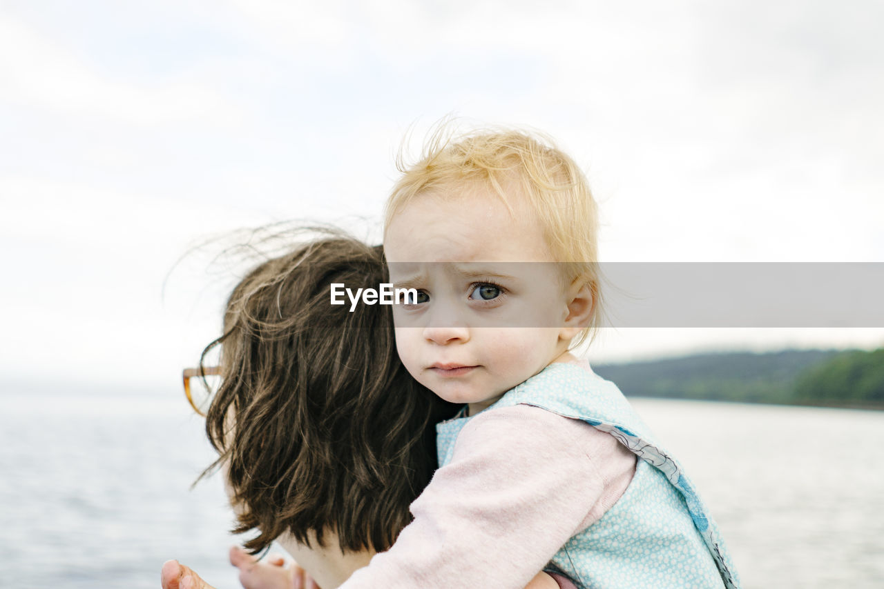 Closeup portrait of a young girl on her mother's shoulders