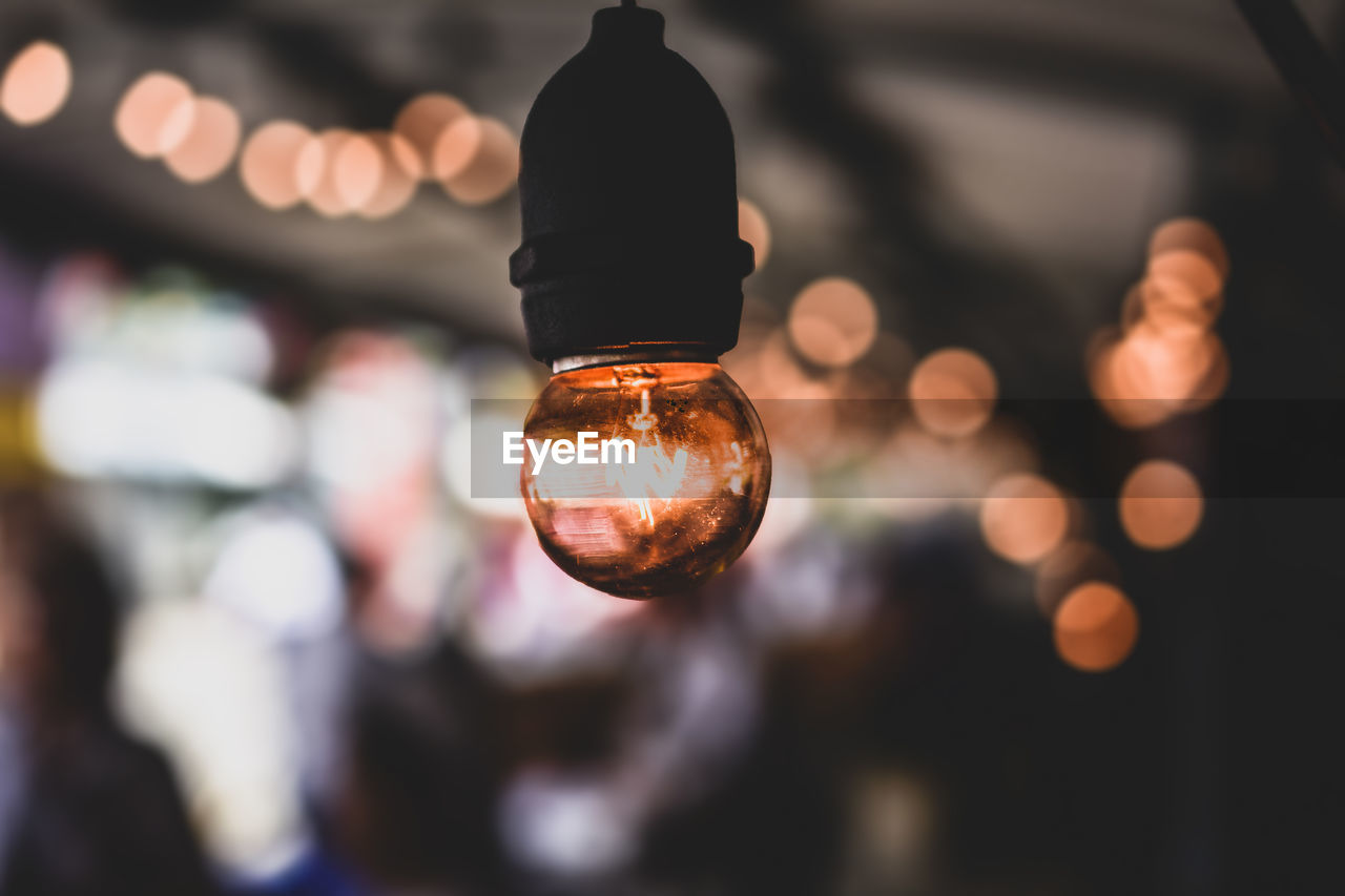 Close-up of illuminated light bulb hanging