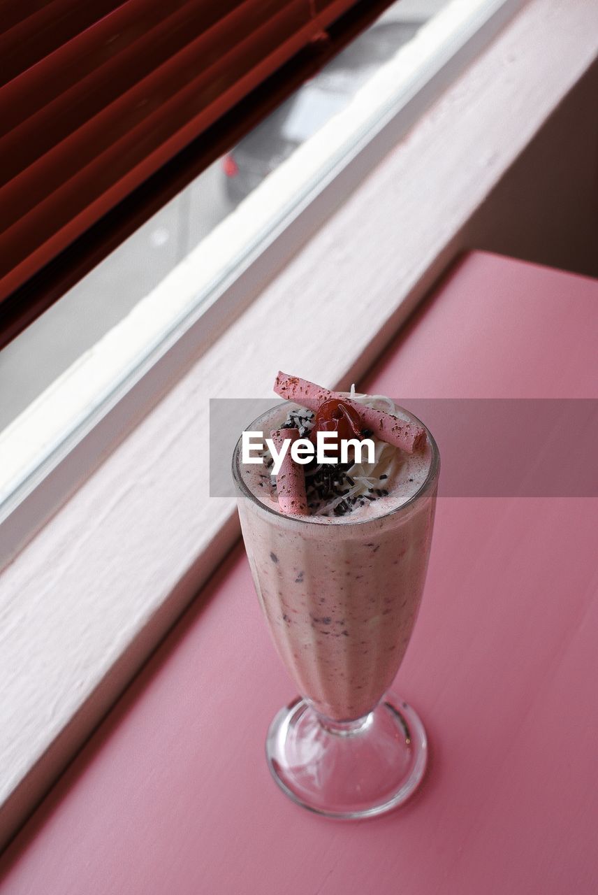 High angle view of milkshake in glass on table