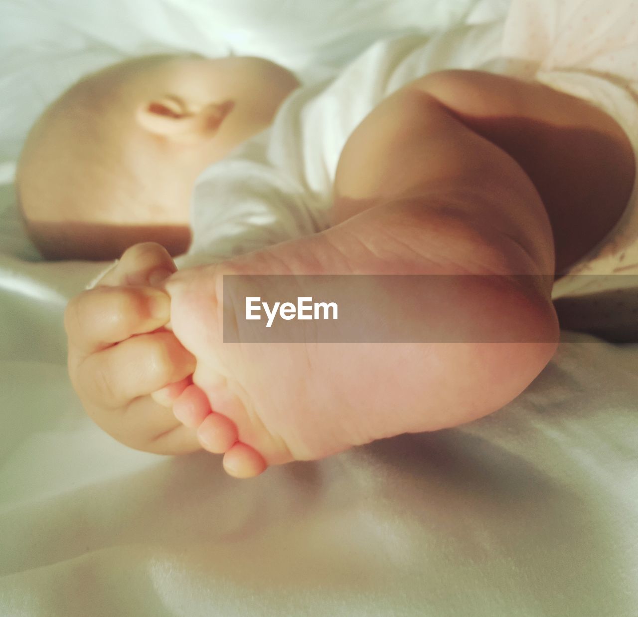Close-up of baby lying on bed at home