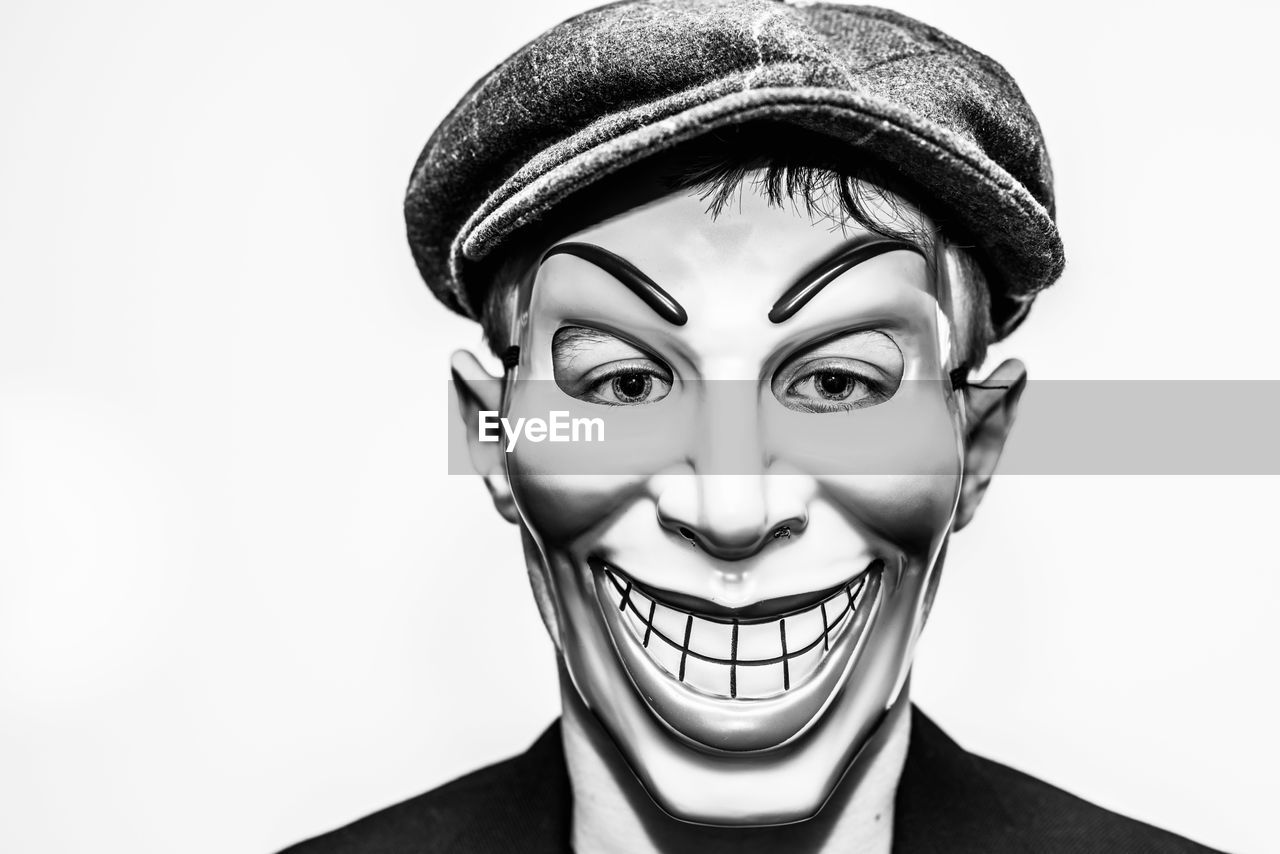 Close-up portrait of teenage boy wearing mask against white background