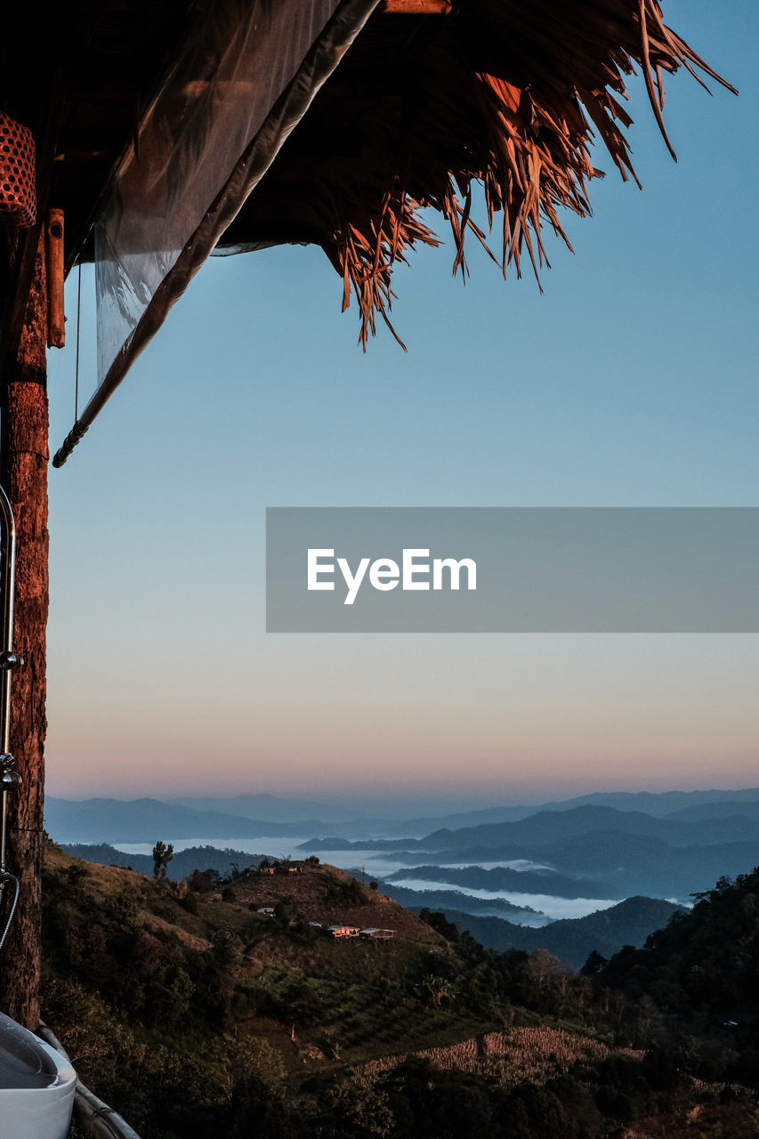 sky, nature, sunset, scenics - nature, sea, water, beauty in nature, evening, architecture, tranquility, land, mountain, dusk, no people, environment, travel destinations, travel, landscape, tranquil scene, horizon, reflection, tree, outdoors, transportation, built structure, beach, horizon over water, clear sky, vehicle, sunlight, mode of transportation, idyllic, non-urban scene, plant