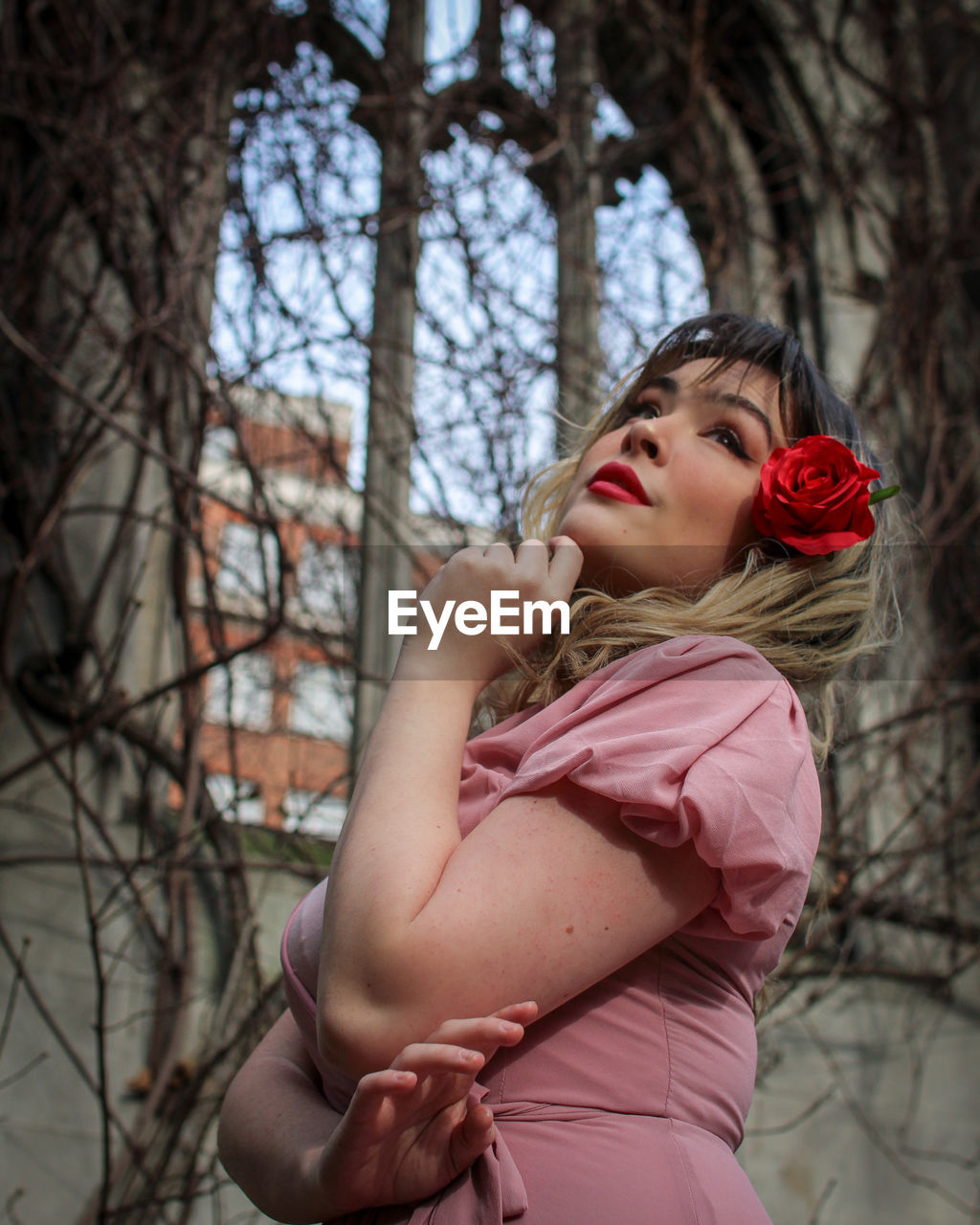 GIRL LOOKING AWAY WHILE STANDING AGAINST TREES