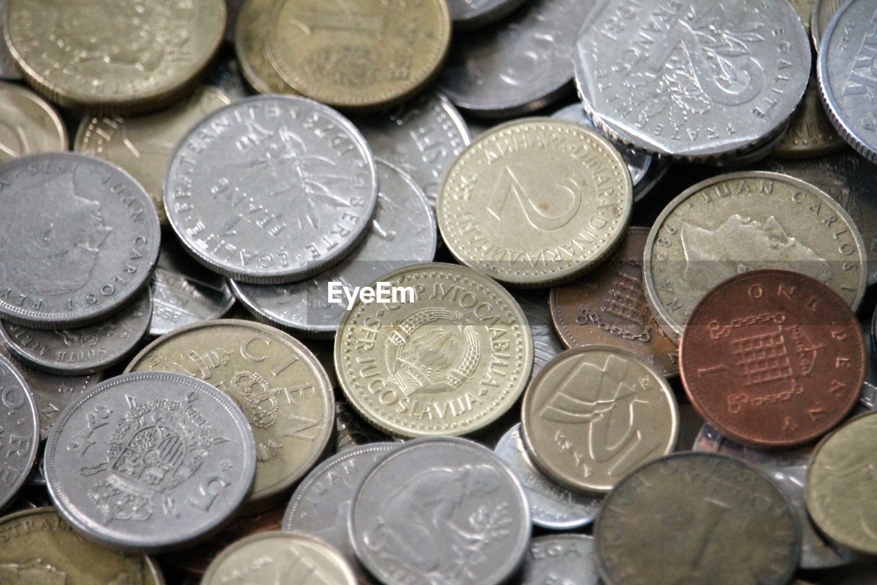 FULL FRAME SHOT OF COINS ON METAL