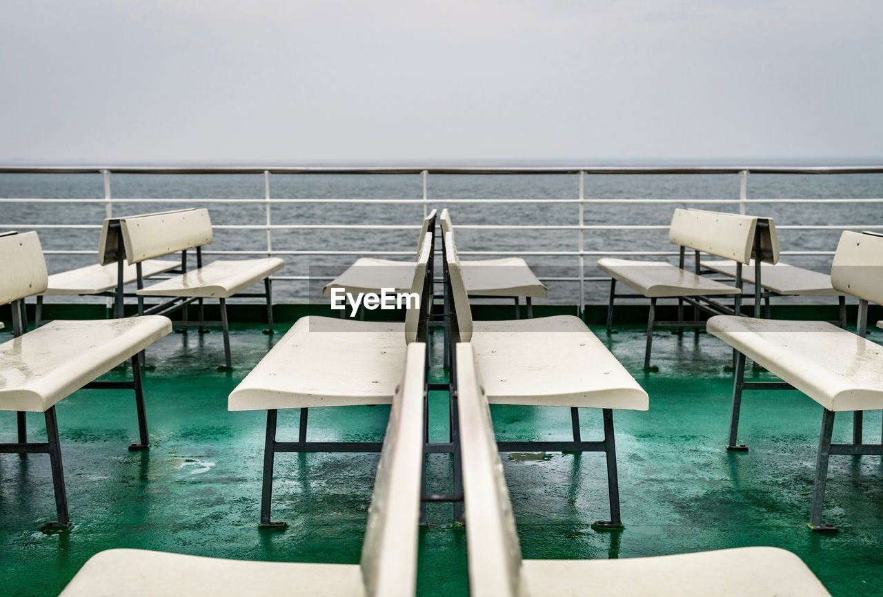 EMPTY CHAIRS AND TABLE ON SEA