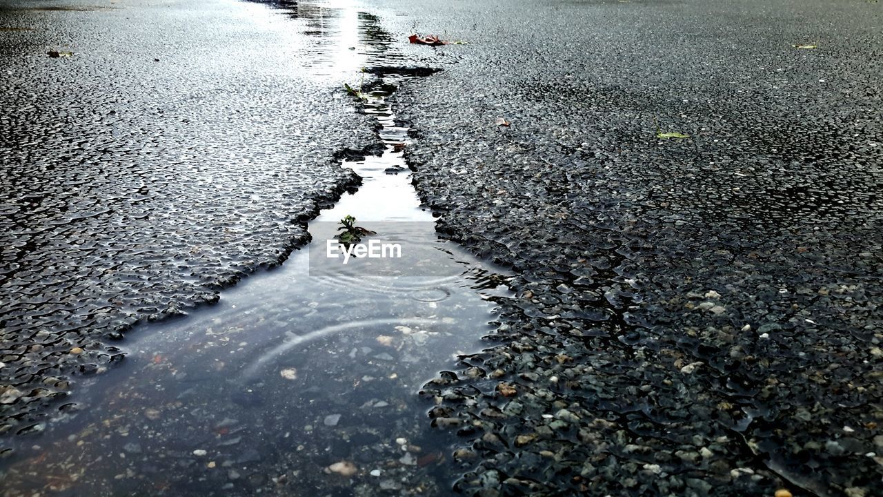 High angle view of water puddle in street crack