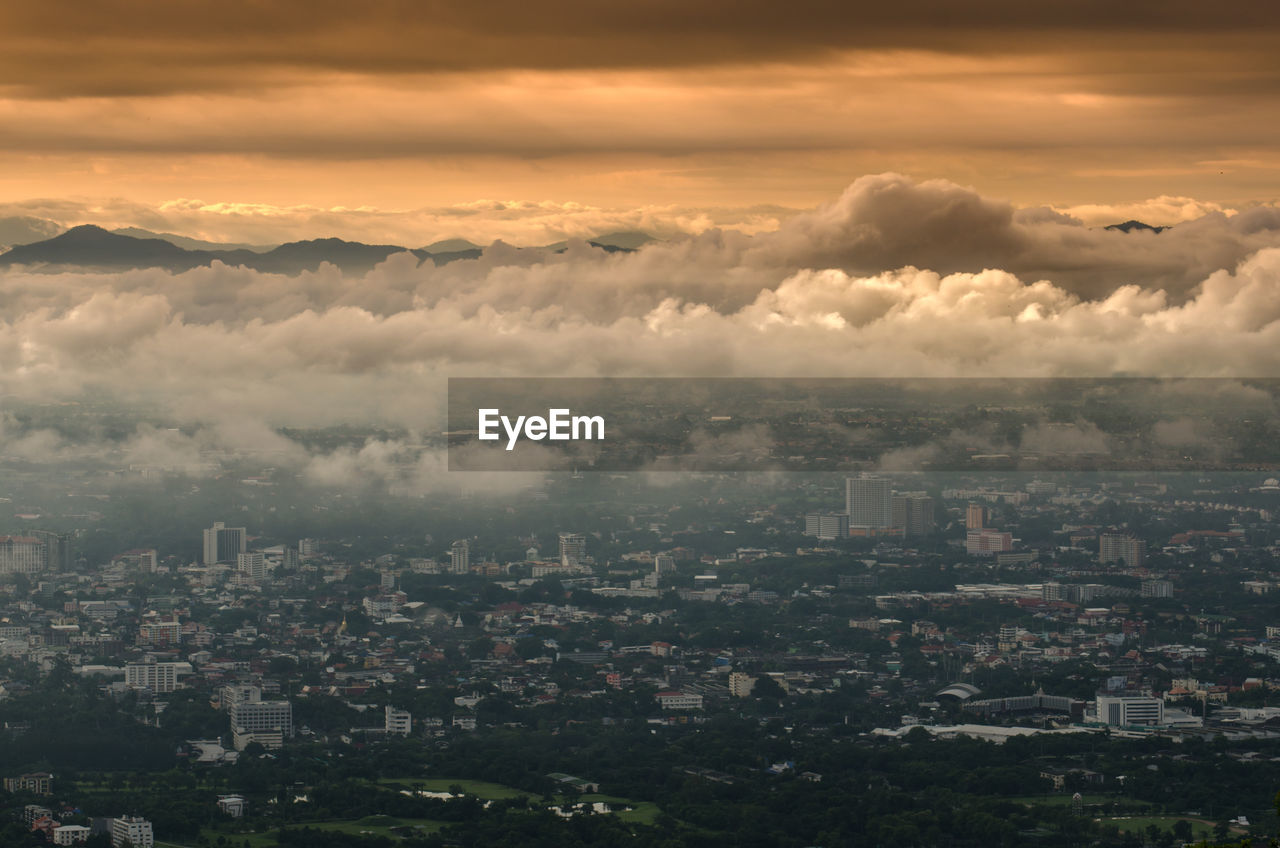 Cloudscape over cityscape during sunset