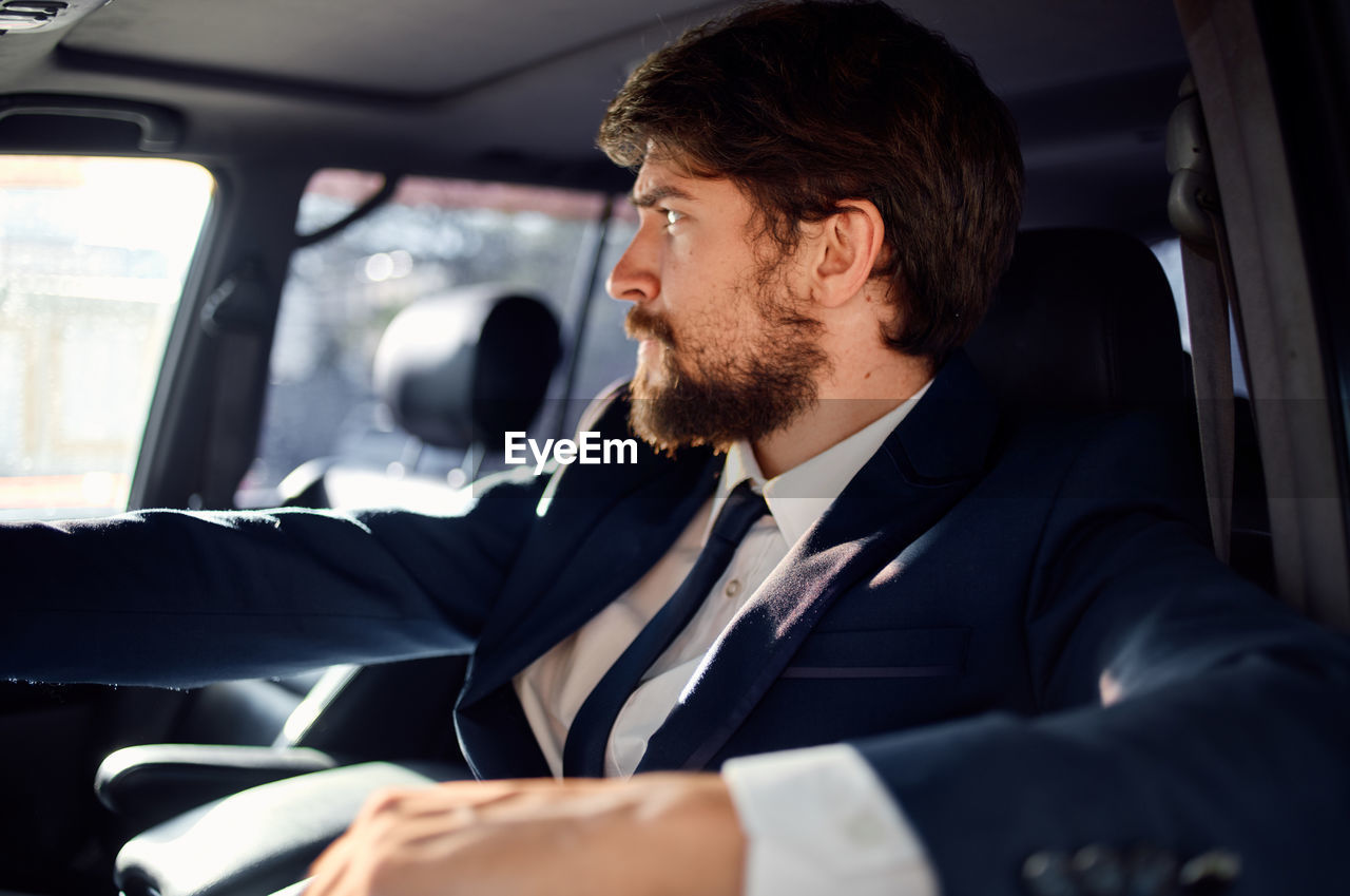 Young man sitting in car