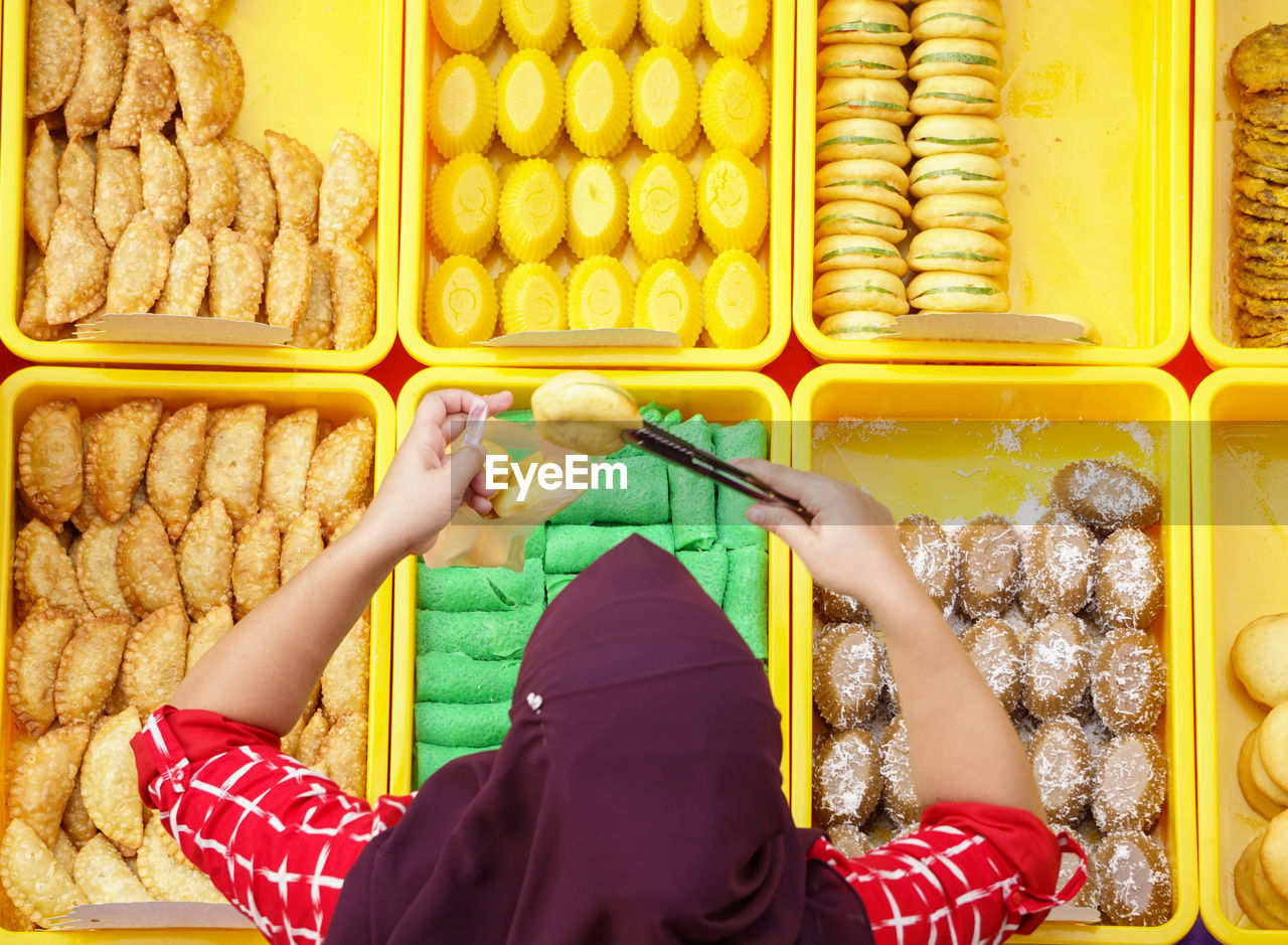 High angle view of woman picking food from basket at shop