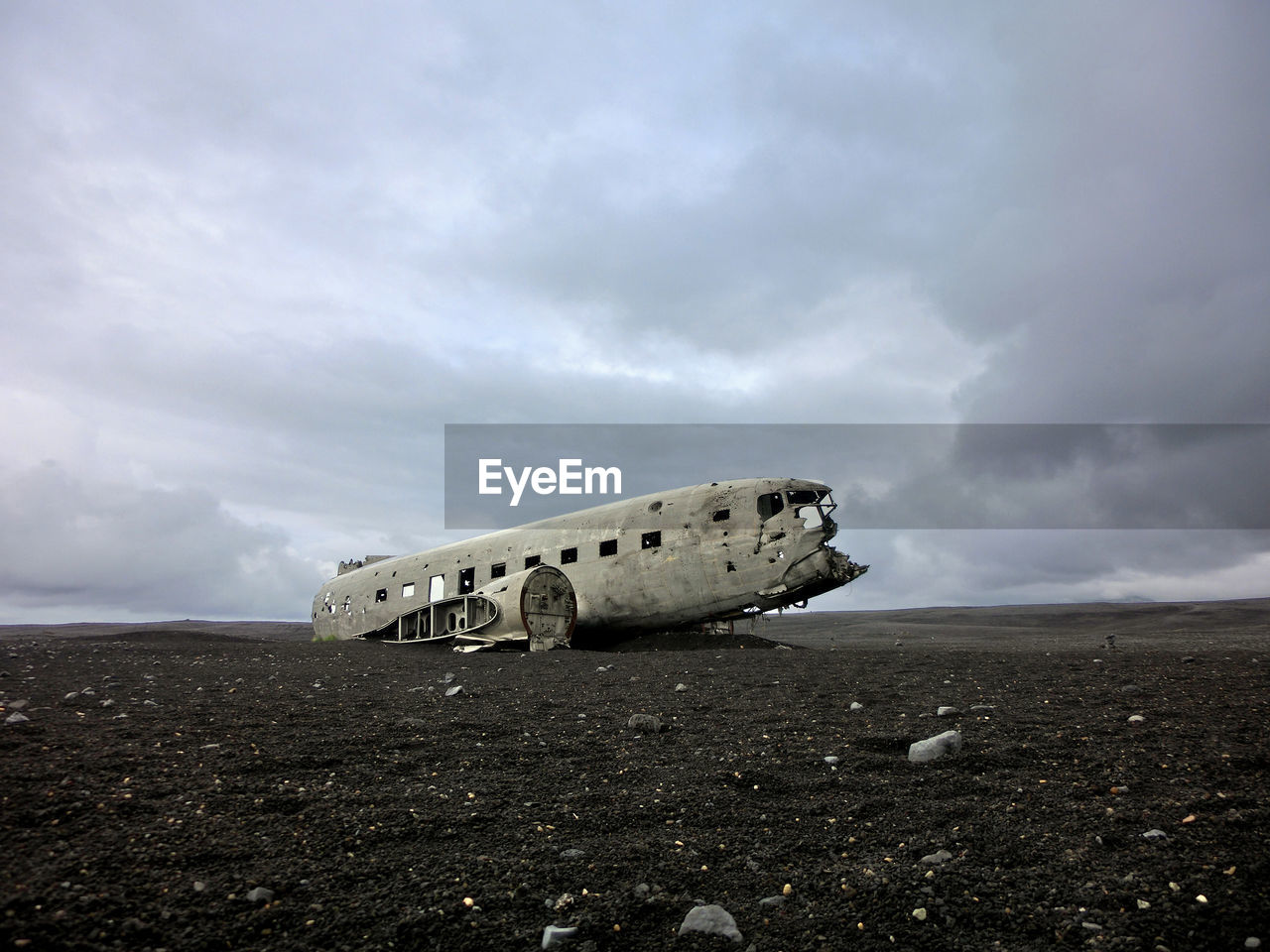 ABANDONED AIRPLANE ON SANDY BEACH AGAINST SKY