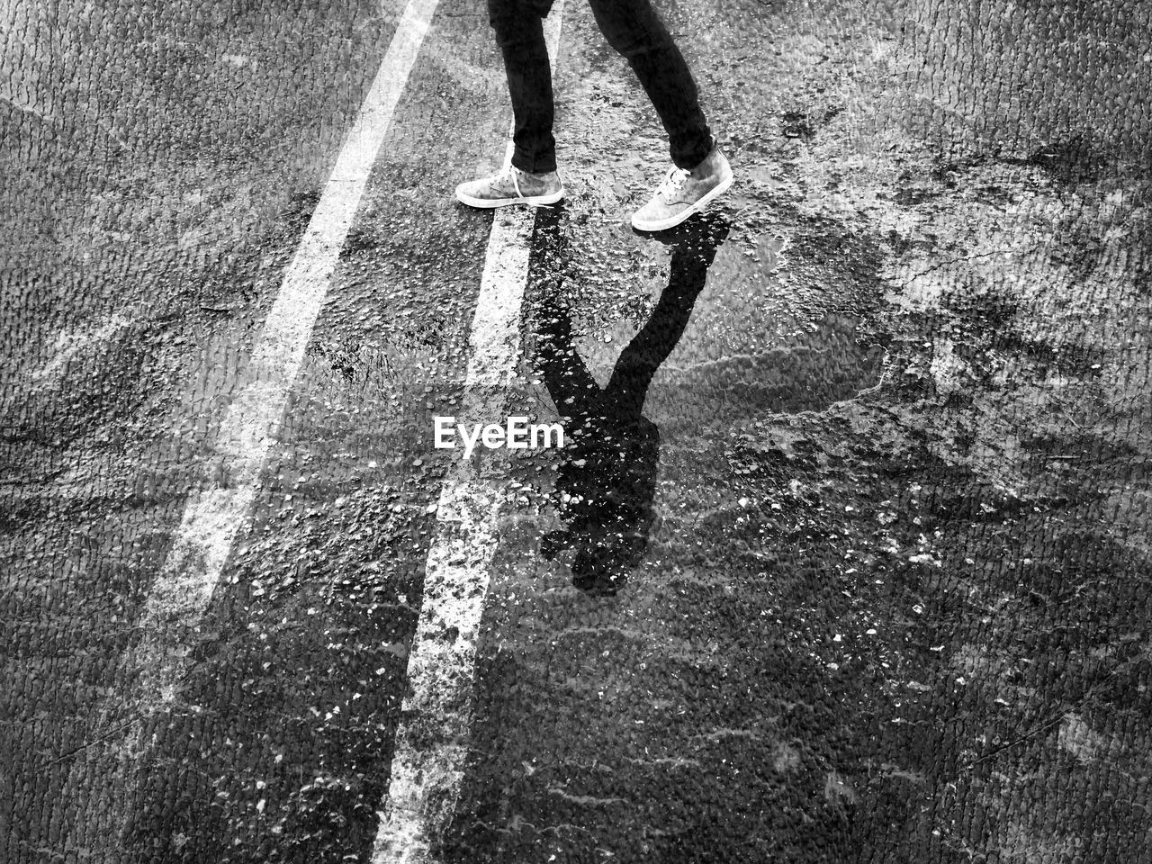 Low section of person walking on wet street