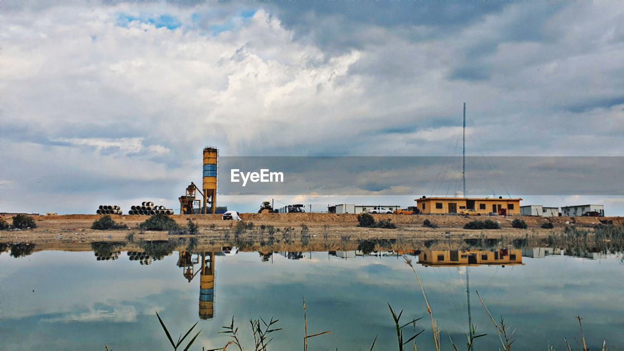 Reflection of building in lake against sky