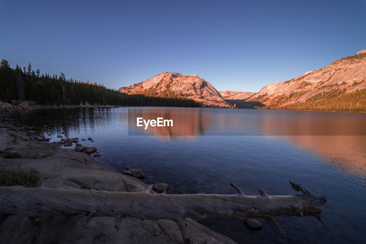 Scenic view of lake by mountains against clear sky