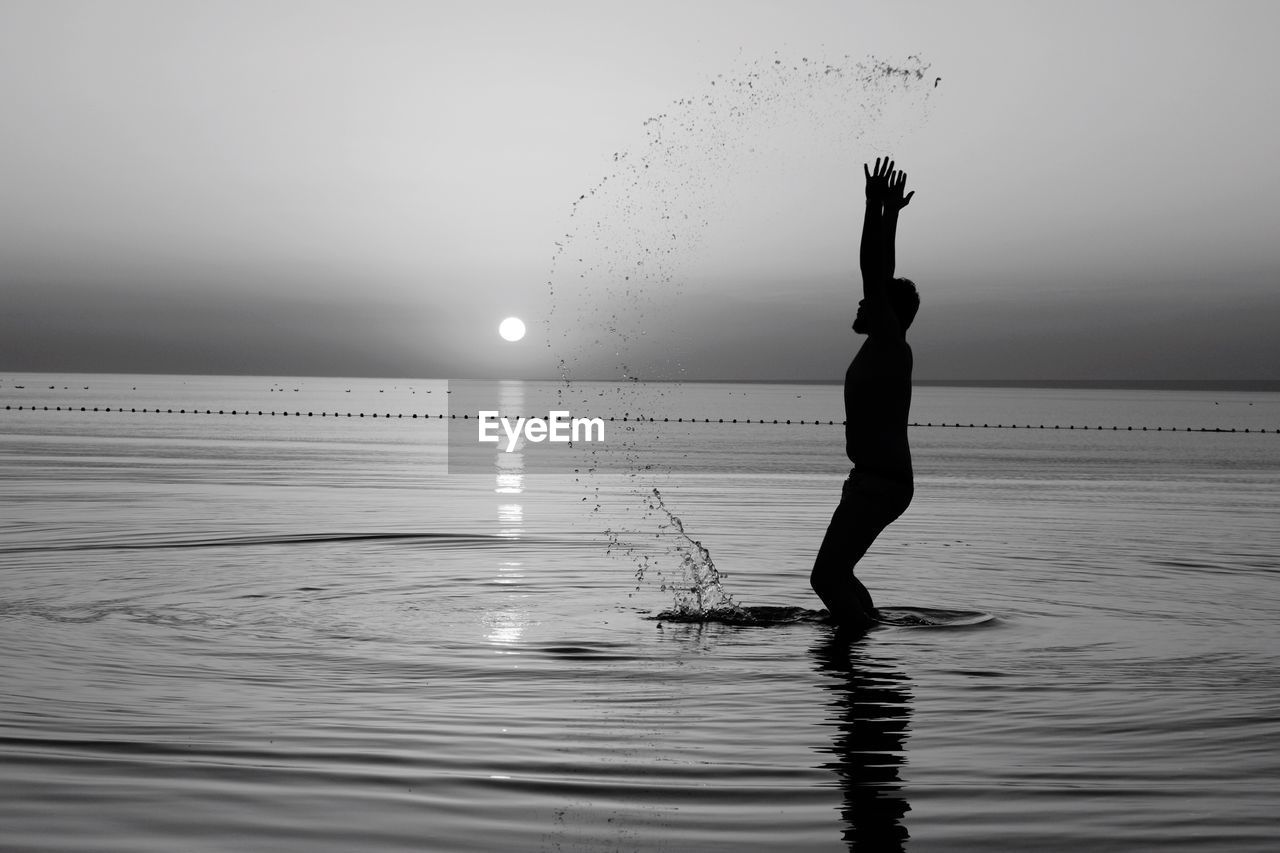 SILHOUETTE WOMAN STANDING ON SEA AGAINST CLEAR SKY