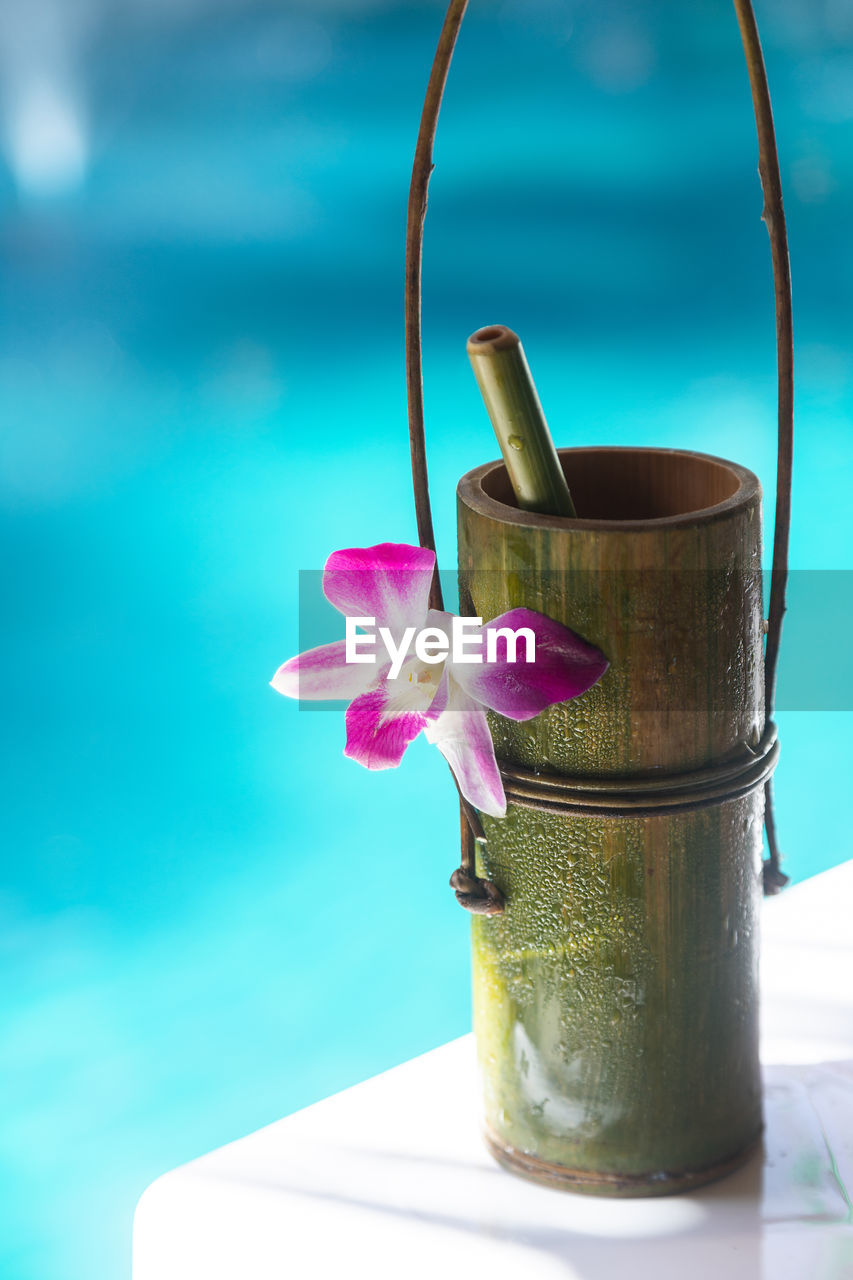 Bamboo natural cup with small bamboo tube, decorate with purple flower, tie together with vine