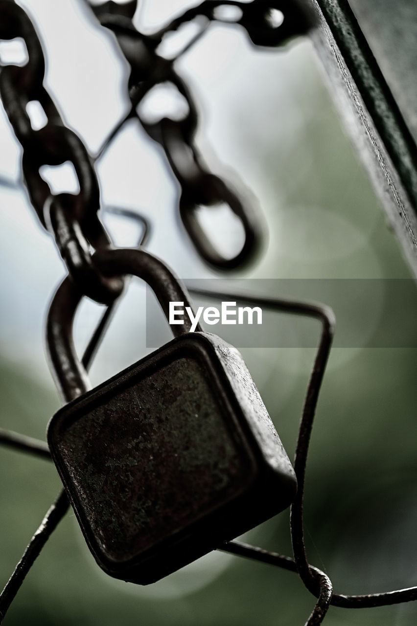 CLOSE-UP OF OLD CHAIN HANGING FROM METAL