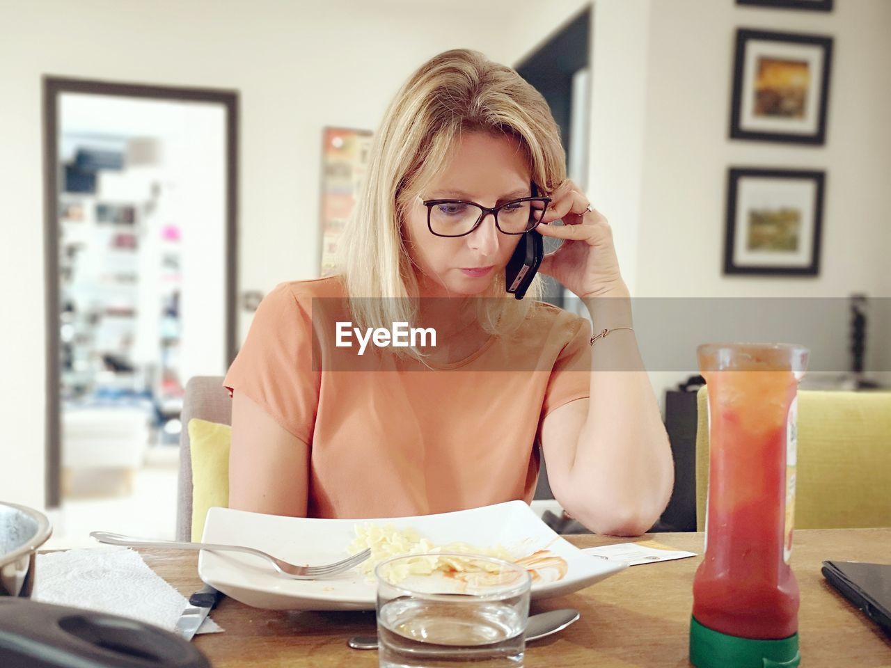 Woman talking on smart phone while sitting on table