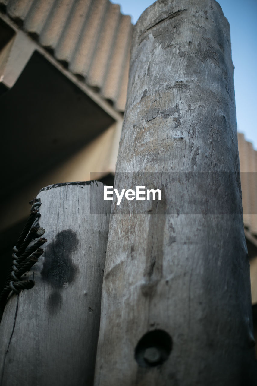 Low angle view of wooden post at harbor