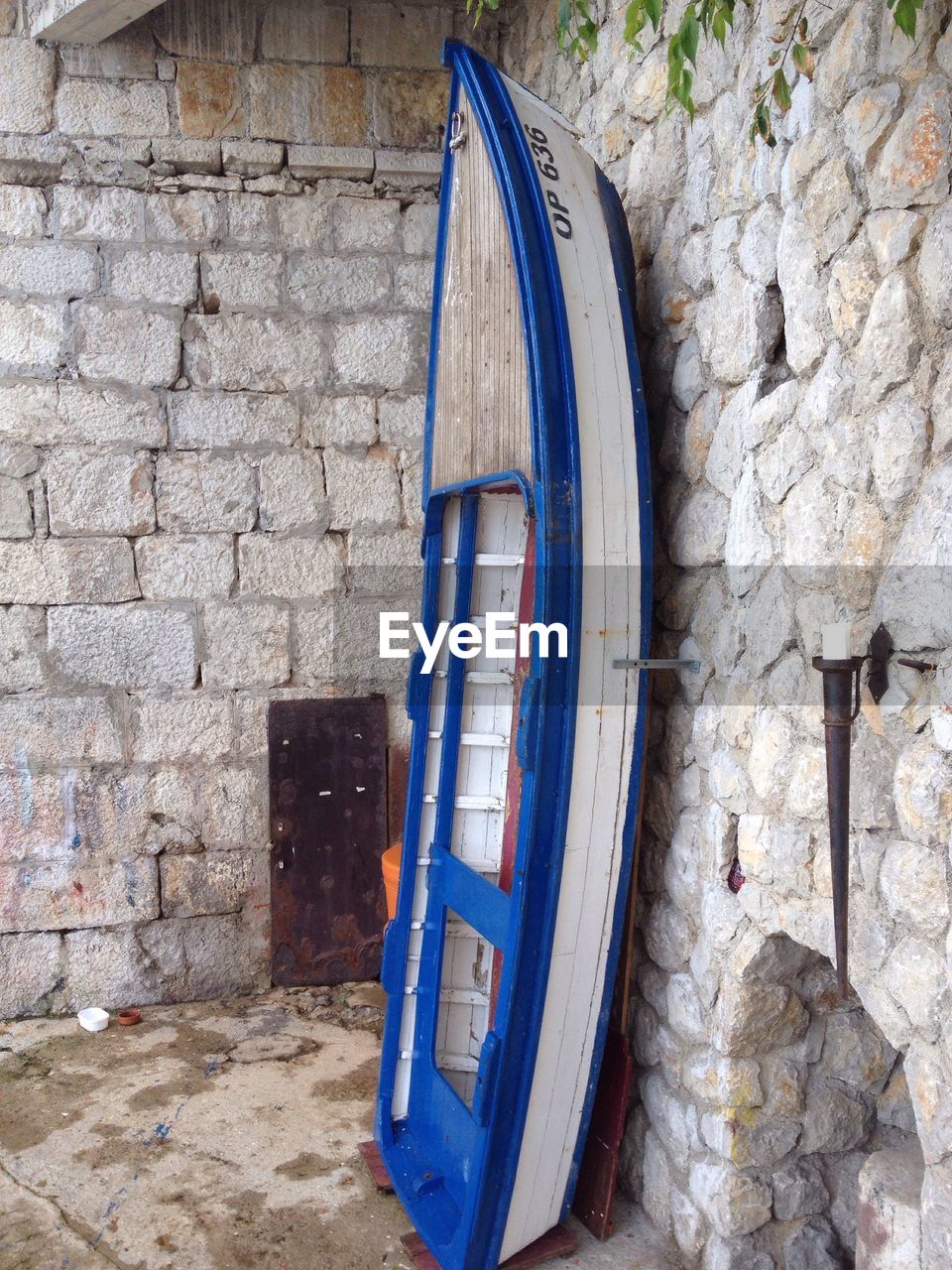 Boat leaning on stone wall