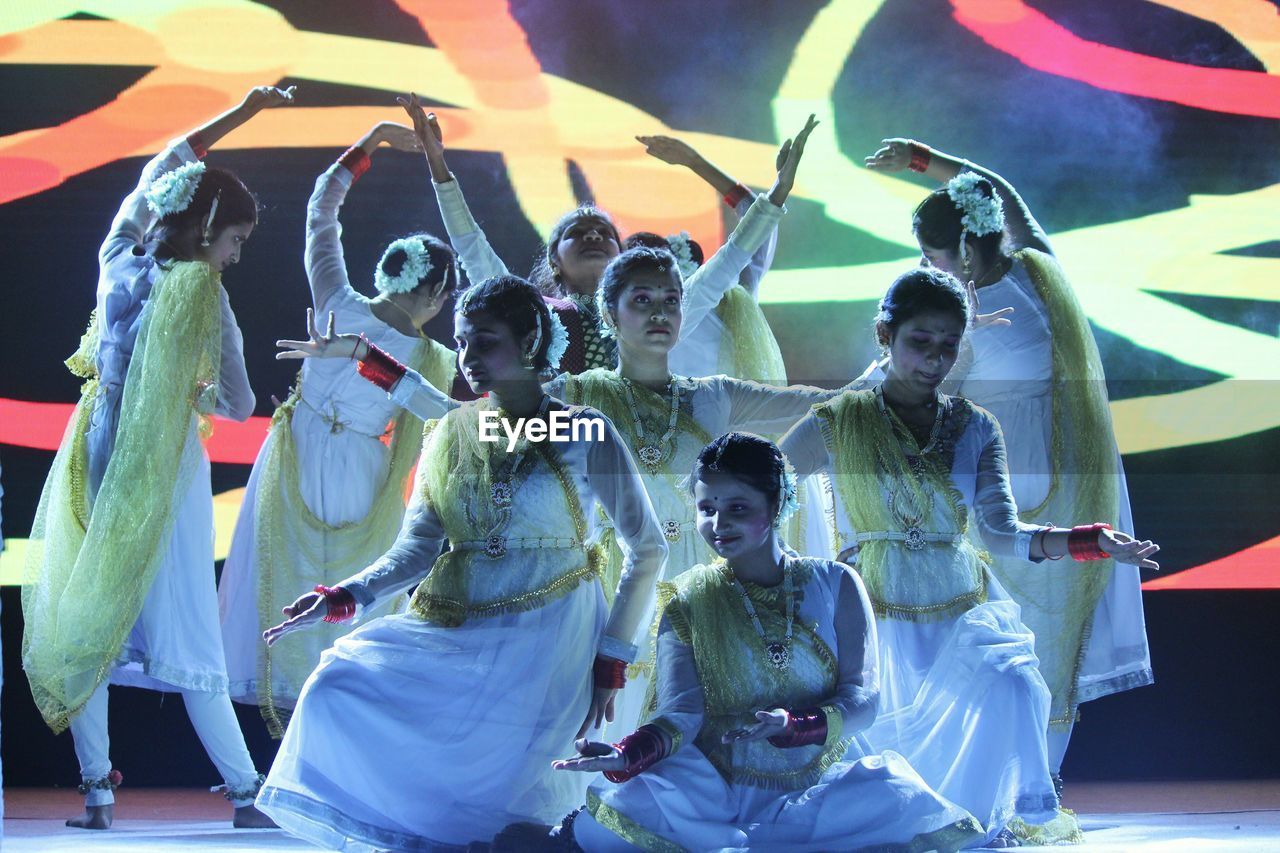 PANORAMIC VIEW OF PEOPLE DANCING AT NIGHT DURING FESTIVAL