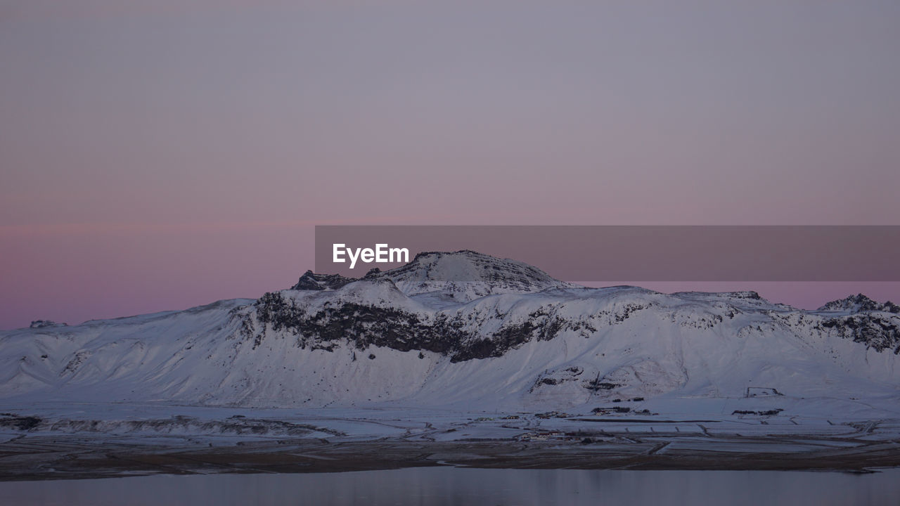 Scenic view of snowcapped mountains against sky during sunset